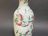 a white vase with a bird on it on a table