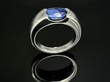 une image représentant une bague ornée d'une pierre bleue sur un fond noir