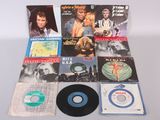 divers disques vinyles et CD posés sur une table avec un fond blanc