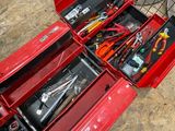 a red tool box with tools in it on the ground