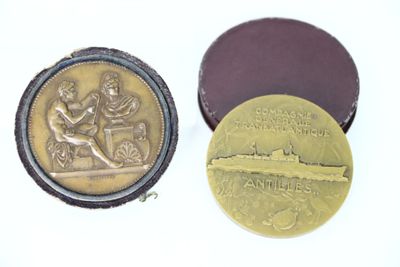 two gold medals sitting next to each other on top of a white surface