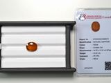 un gros plan d'un saphir orange dans un écrin