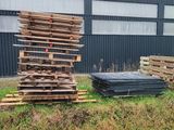 un tas de bois posé dans l'herbe à côté d'un bâtiment