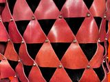 a close up of a red and black dress with metal studding
