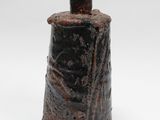 une image représentant un vase noir posé sur une surface blanche