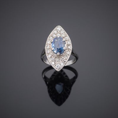 a blue sapphire and diamond ring on a black surface
