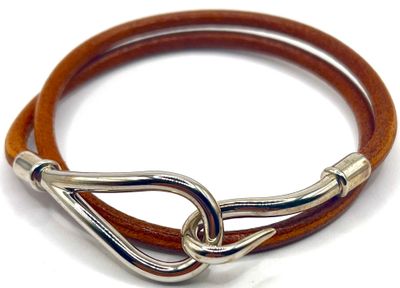 bracelet en cuir marron avec un fermoir argenté sur fond blanc