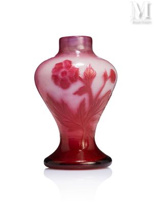 a red vase with flowers on it on a white surface