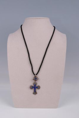 a close up of a necklace with a cross on a mannequin