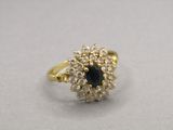 a close up of a gold ring with a black stone surrounded by white diamonds