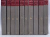 several books are lined up in a row on a white surface