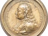 an image of a gold medal with a portrait of a man on it