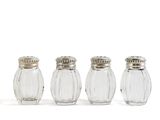 four glass salt and pepper shakers lined up on a white surface