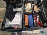 a black container filled with assorted items on the floor