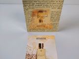 a box of perfume sitting on top of a table next to a piece of paper