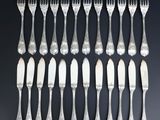 twelve silverplated forks and spoons on a black background