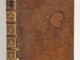 an old book sitting on top of a white table next to a white wall