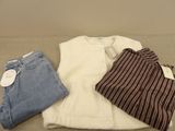 two pairs of jeans and a t - shirt are sitting on a couch