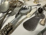 a table with a lot of silverware and silverware on it