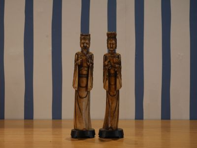 deux figurines en bois posées sur une table