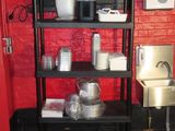 a black shelf with pots and pans on top of it
