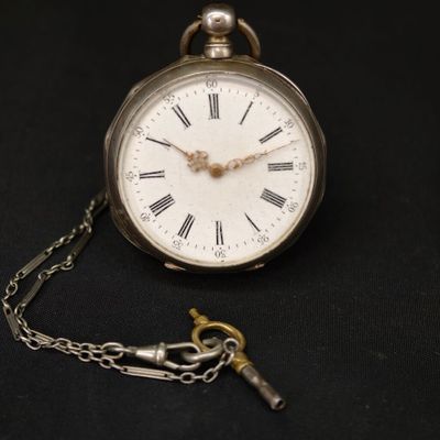 une montre de poche en argent avec des chiffres romains