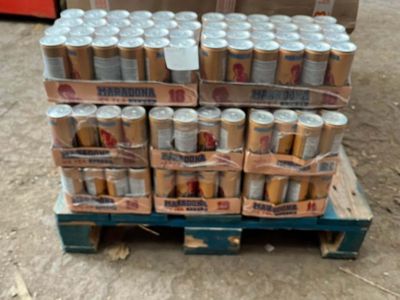 several cans of beer are stacked on a pallet in a warehouse