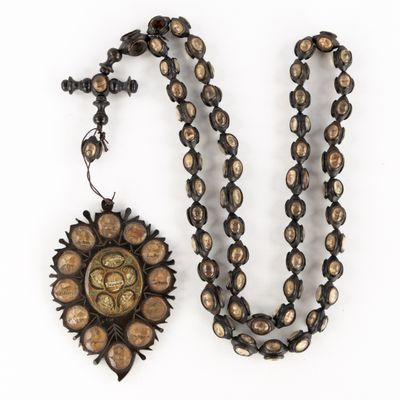 a close up of a necklace and a pendant on a white surface