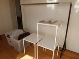a white shelf with two white tables on it