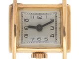 une image montrant un gros plan d'une montre en or avec un cadran blanc