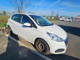 a small white car parked in a parking lot