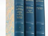 Trois livres bleus sont empilés les uns sur les autres sur une étagère