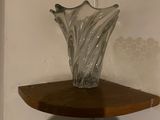 a glass vase sitting on top of a wooden shelf