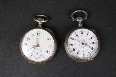 deux montres de poche en argent posées côte à côte sur une surface noire