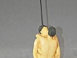 une figurine représentant un homme assis sur une lampe