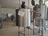 un grand réservoir métallique sur lequel est apposée une pancarte, dans une pièce