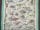 foulard carré vert et blanc orné d'un motif représentant des oiseaux sur une clôture grillagée