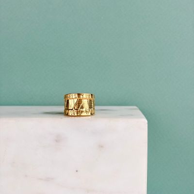 un bloc de marbre surmonté d'un anneau doré, sur fond bleu