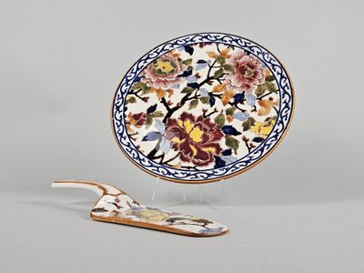 une assiette ornée d'un motif floral, à côté d'une cuillère en bois