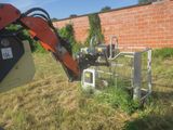 a machine that is sitting in the grass near a brick wall