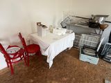 a table with a white tablecloth and red chairs in a kitchen
