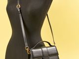 un sac à main noir posé sur un mannequin