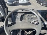 a steering wheel and dashboard of a truck in a parking lot