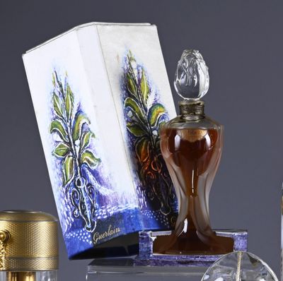 a bottle of perfume sitting on a table next to a box
