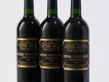 three bottles of wine sitting on top of a white table