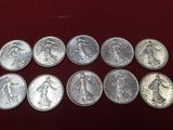 a bunch of silver coins sitting on top of a red surface