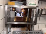 a metal shelf with a basket on it in a kitchen