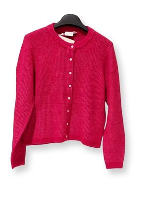 pink cardigan sweater hanging on a hanger on a white wall