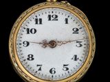gros plan d'une montre de poche en or sur fond noir