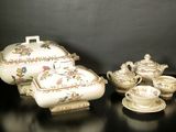 three pieces of porcelain on a table with a black background